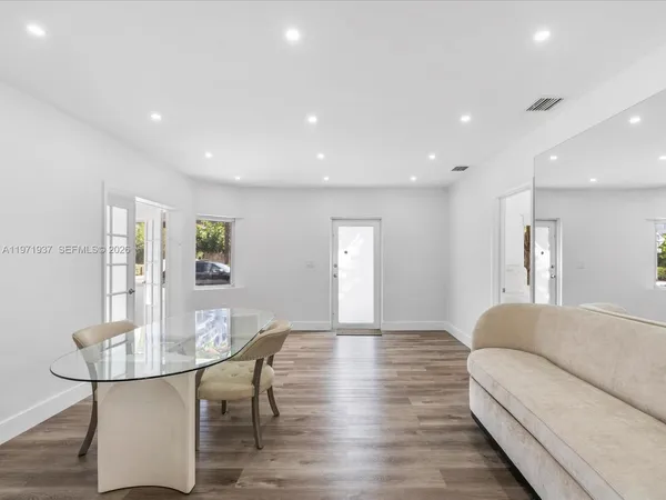 a living room with furniture a table and wooden floor