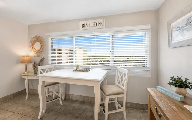 a room with a table chairs and a window