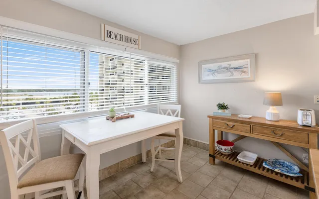 a kitchen with stainless steel appliances a table chairs and a refrigerator