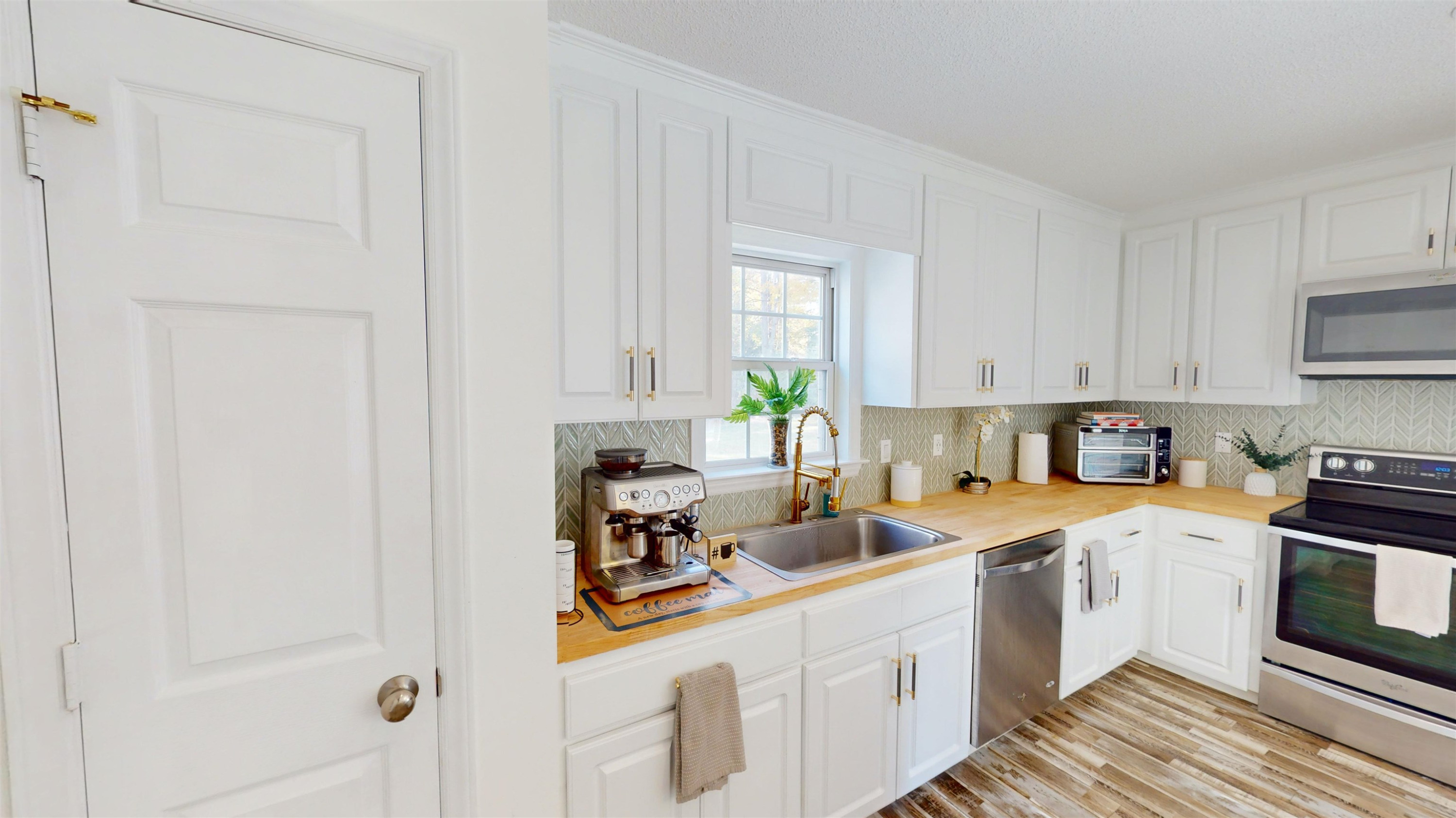 1036 Drew Drive Garner, NC 27529 - Photo 13 of 59 a kitchen with white cabinets and white appliances