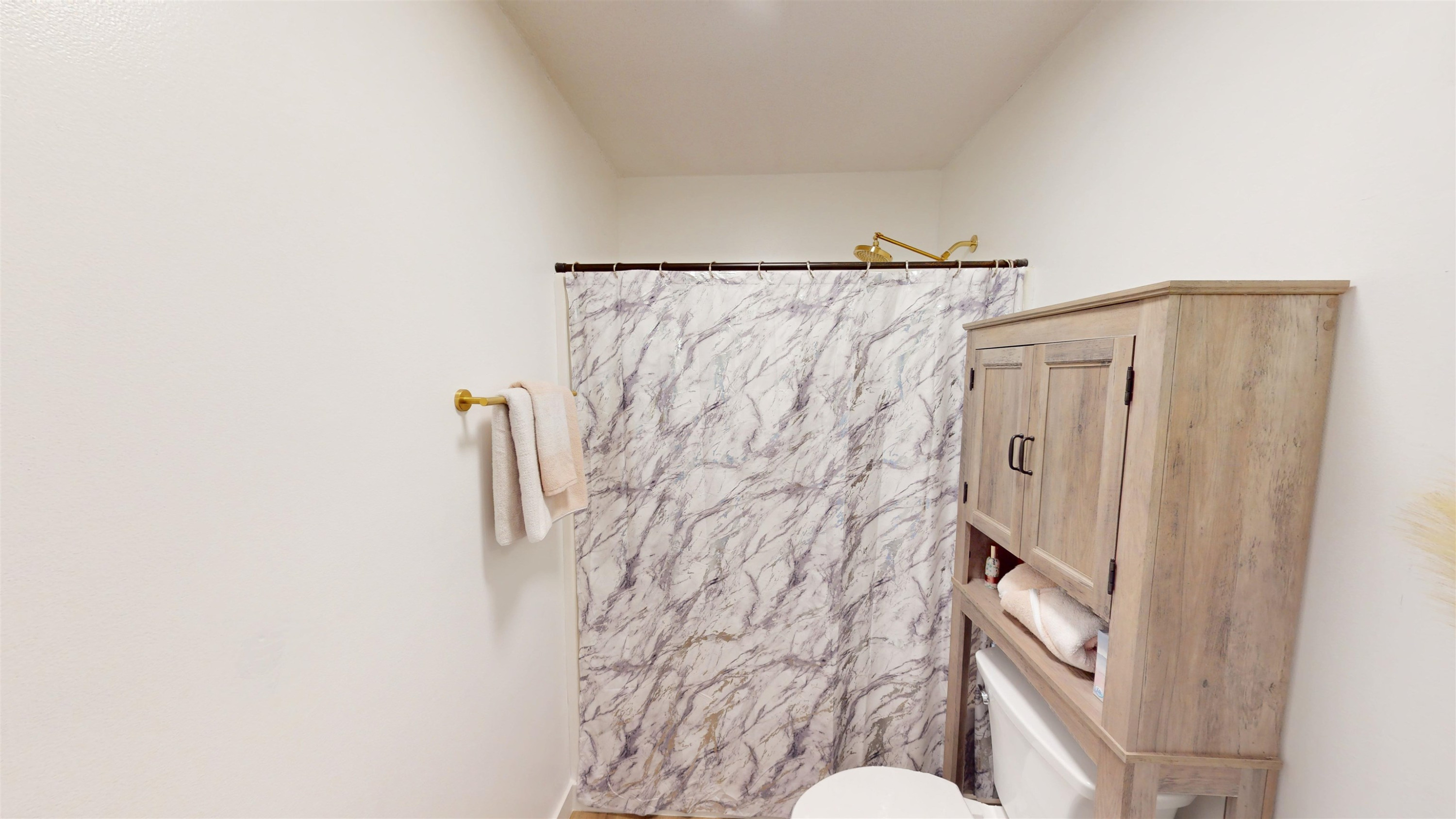 1036 Drew Drive Garner, NC 27529 - Photo 37 of 59 a bathroom with a shower curtain and a toilet