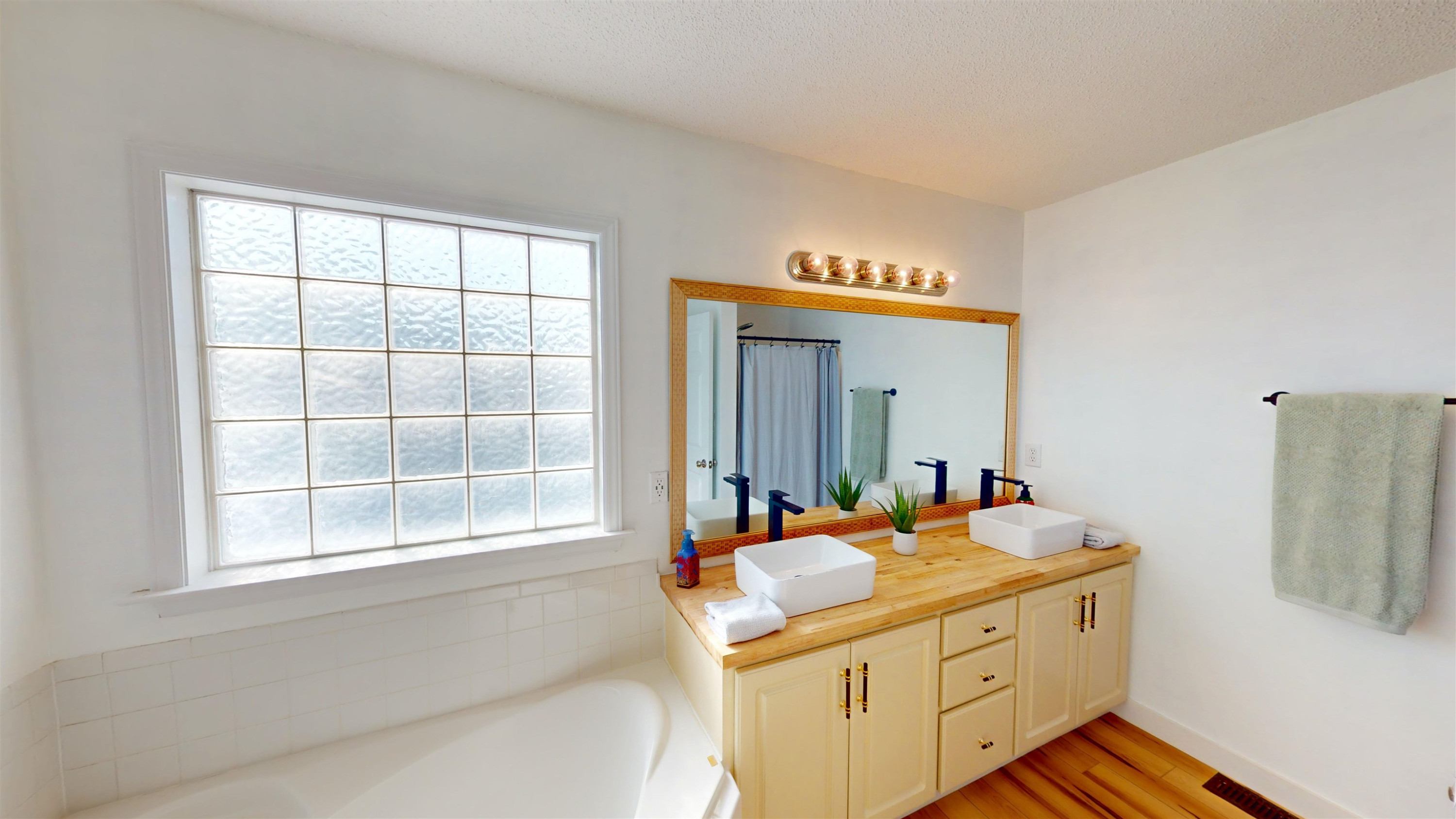 1036 Drew Drive Garner, NC 27529 - Photo 44 of 59 a bathroom with a sink a vanity and a large mirror next to a window