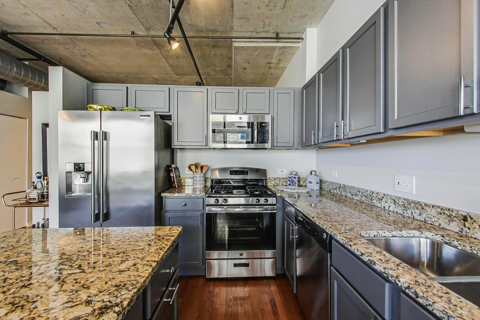 933 West Van Buren Street, Unit 726 Chicago, IL 60607 - Photo 12 of 31 a kitchen with stainless steel appliances granite countertop a refrigerator a stove and a sink