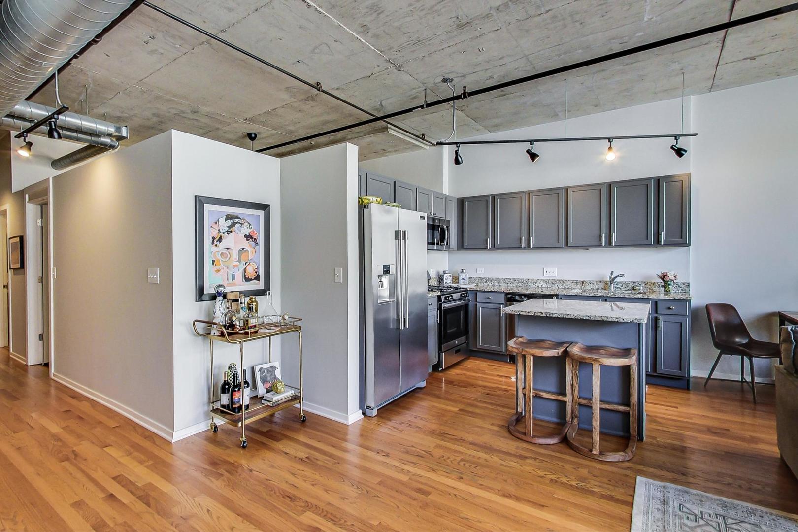 933 West Van Buren Street, Unit 726 Chicago, IL 60607 - Photo 13 of 31 a view of kitchen with refrigerator and wooden floor