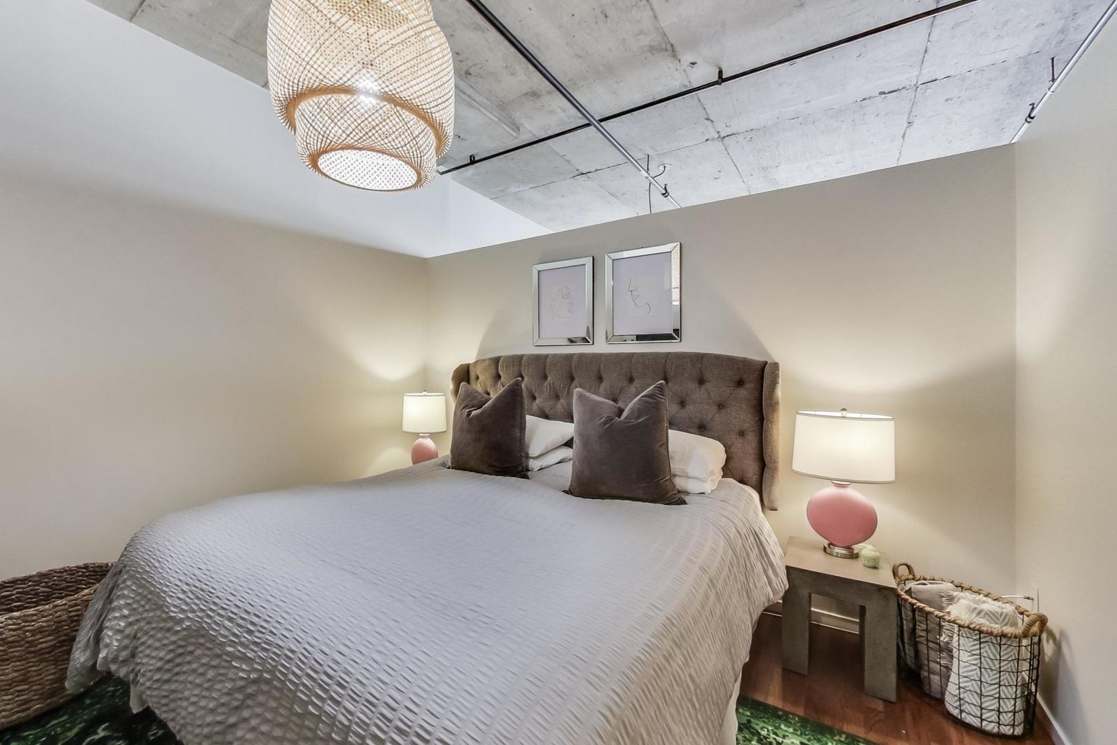933 West Van Buren Street, Unit 726 Chicago, IL 60607 - Photo 15 of 31 a bedroom with a bed and cabinets