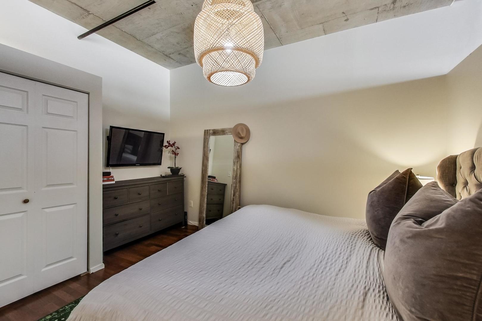 933 West Van Buren Street, Unit 726 Chicago, IL 60607 - Photo 16 of 31 a bedroom with a bed and a television