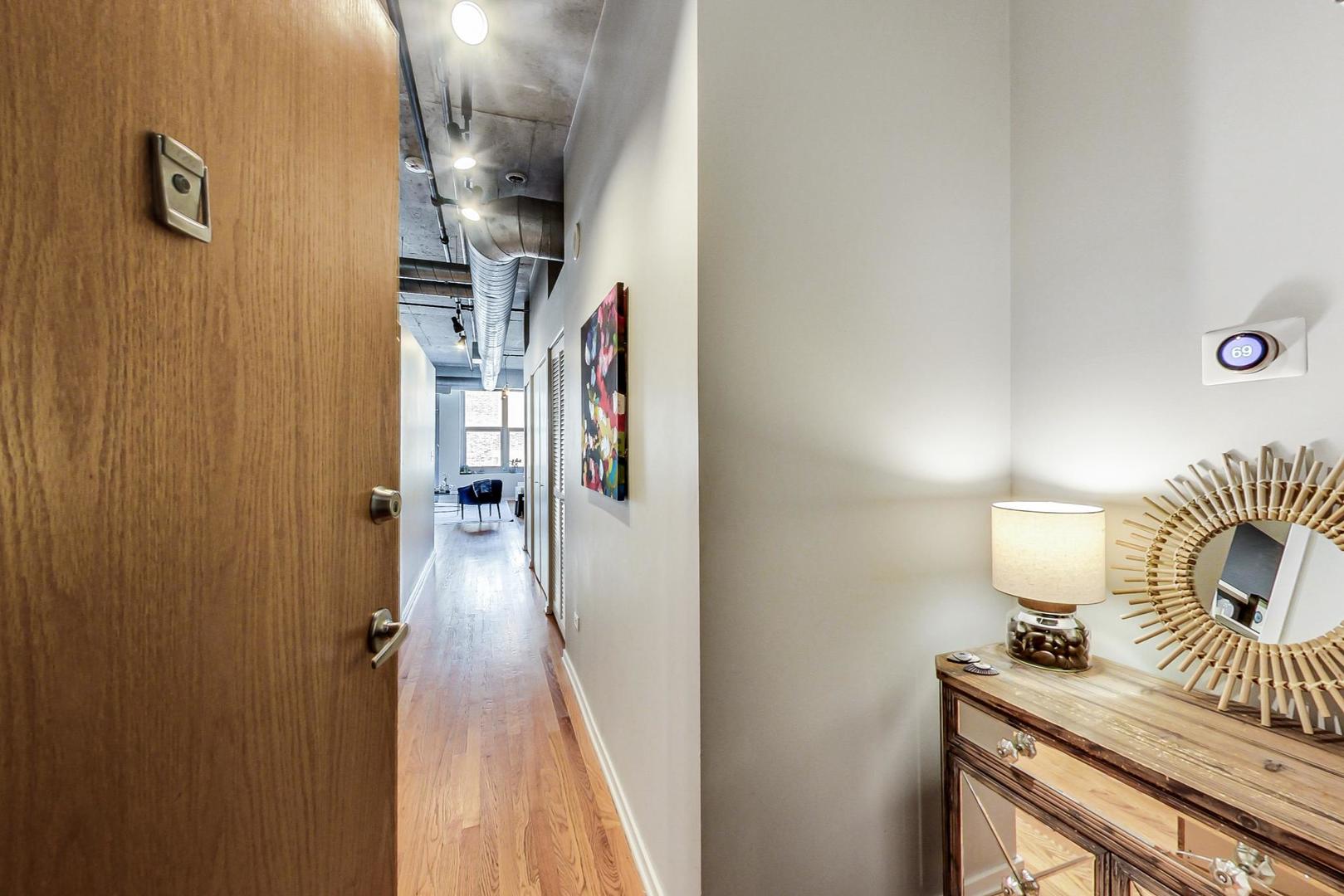 933 West Van Buren Street, Unit 726 Chicago, IL 60607 - Photo 6 of 31 a view of a hallway with wooden floor and staircase