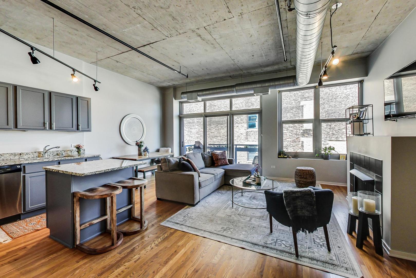 933 West Van Buren Street, Unit 726 Chicago, IL 60607 - Photo 9 of 31 a view of a dining room with furniture a rug and wooden floor