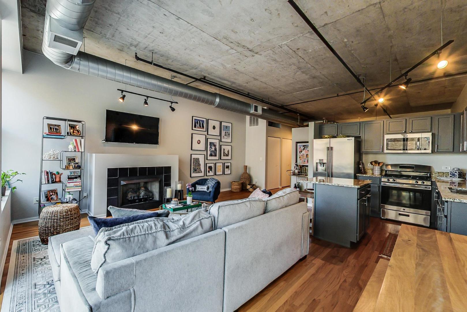933 West Van Buren Street, Unit 726 Chicago, IL 60607 - Photo 10 of 31 a living room with furniture and a fireplace