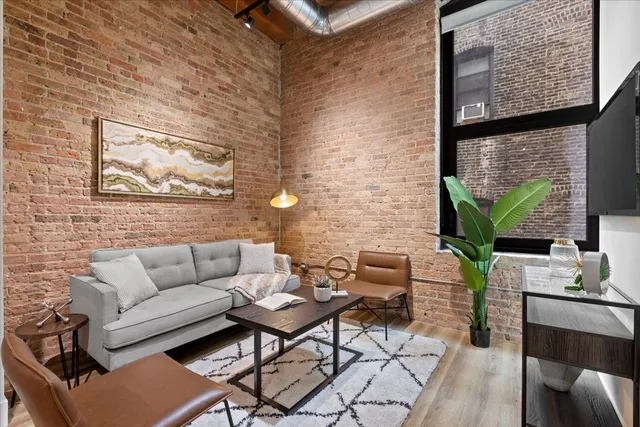a living room with furniture a flat screen tv and a floor to ceiling window