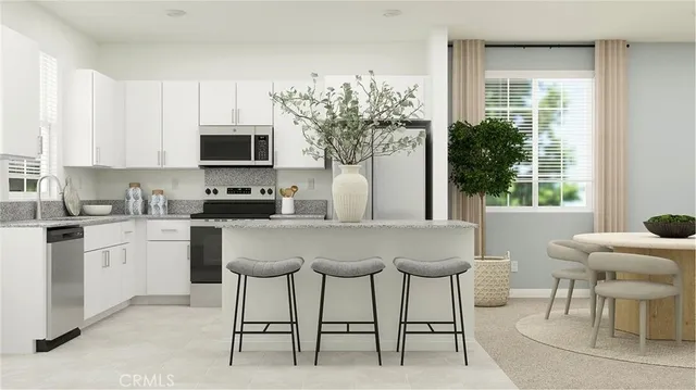 a kitchen with stainless steel appliances granite countertop a stove top oven a sink a dining table and chairs