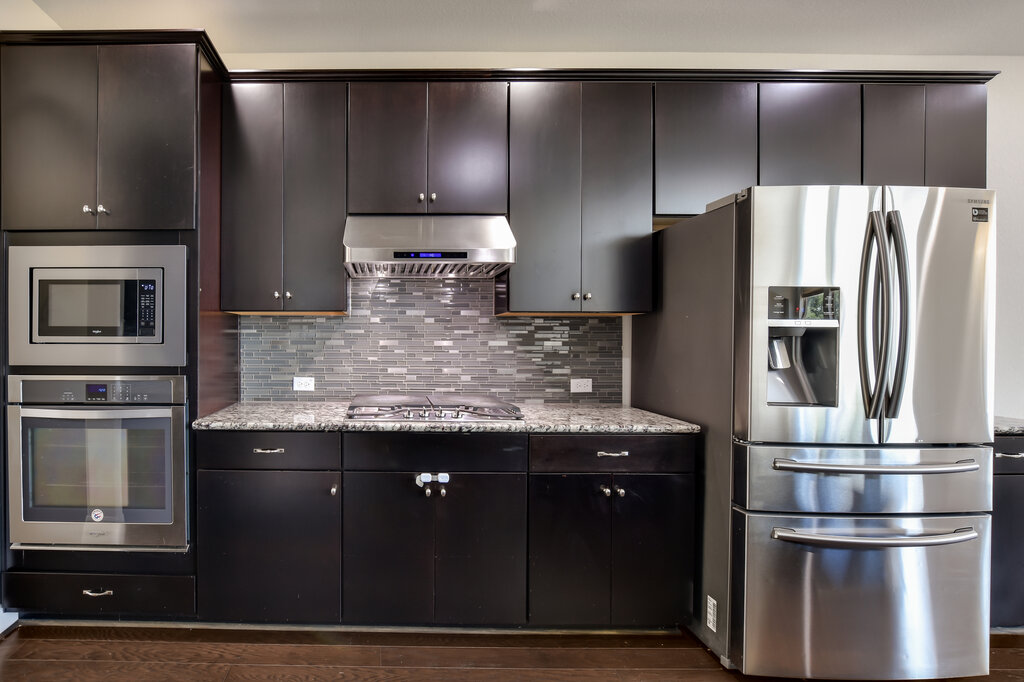 2521 Blended Tree Ranch Drive Leander, TX 78641 - Photo 12 of 40 a kitchen with metallic refrigerator and microwave