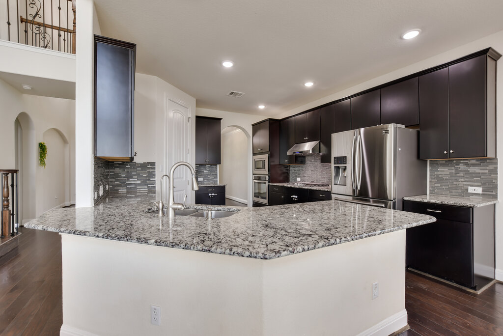 2521 Blended Tree Ranch Drive Leander, TX 78641 - Photo 14 of 40 a kitchen with stainless steel appliances granite countertop a refrigerator a sink and a stove