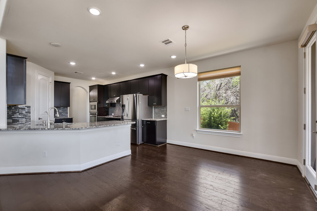 2521 Blended Tree Ranch Drive Leander, TX 78641 - Photo 16 of 40 a view of a kitchen with a refrigerator and a stove