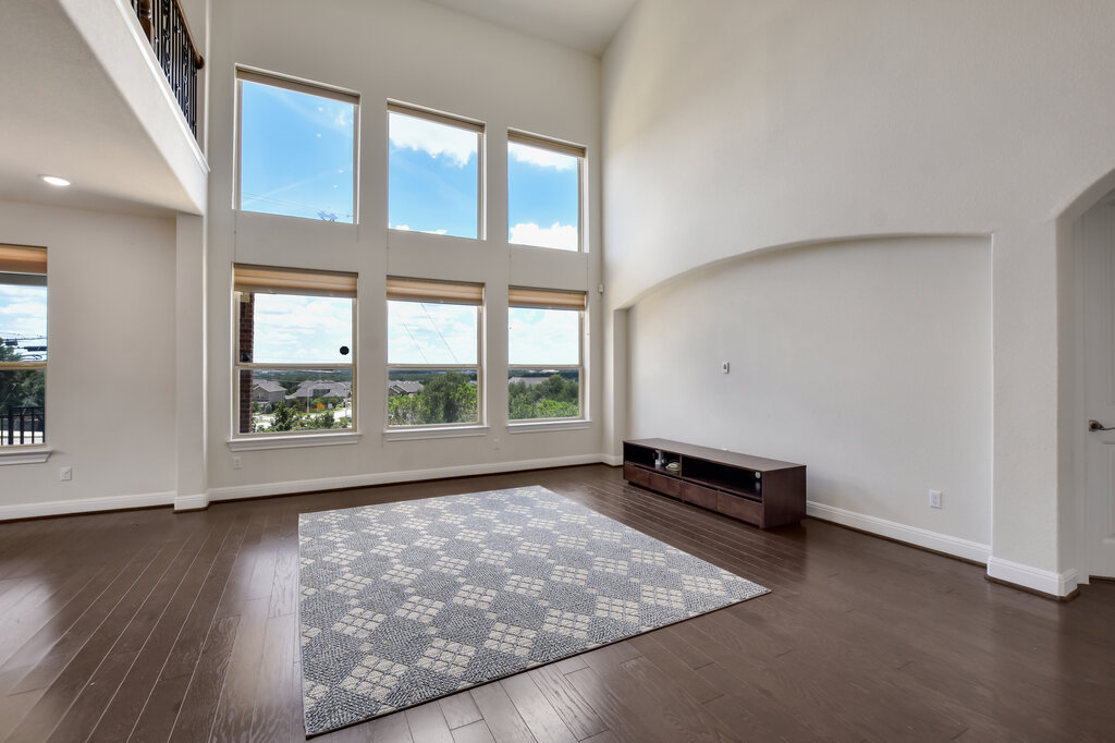 2521 Blended Tree Ranch Drive Leander, TX 78641 - Photo 18 of 40 an empty room with wooden floor and windows