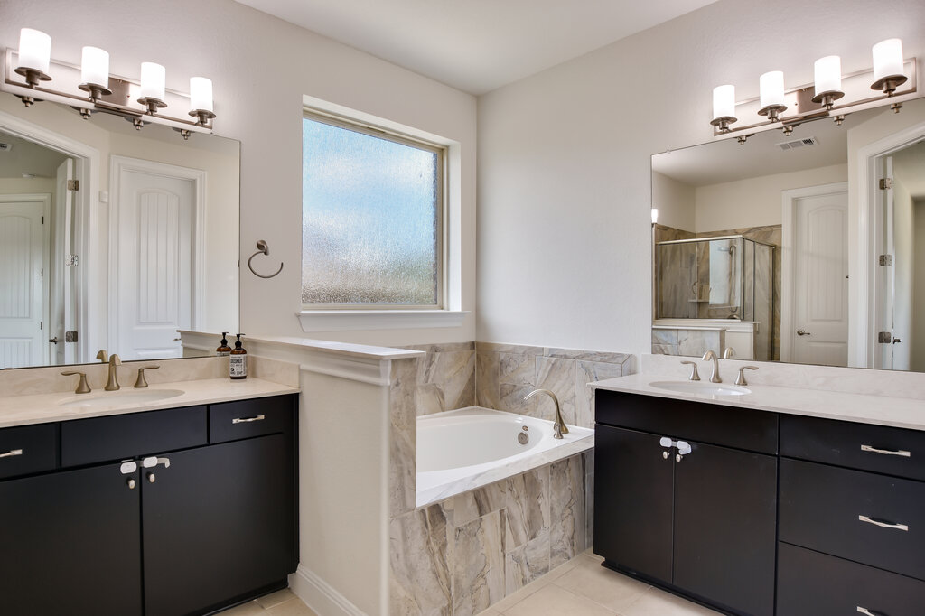 2521 Blended Tree Ranch Drive Leander, TX 78641 - Photo 24 of 40 a bathroom with a sink double vanity granite tub and a mirror