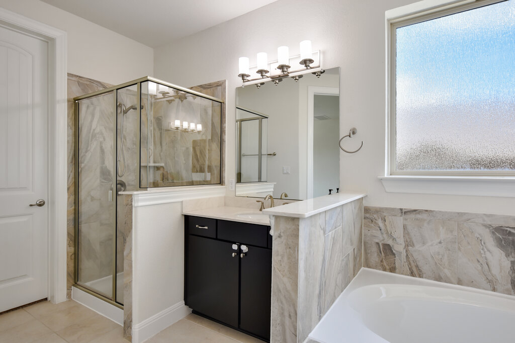 2521 Blended Tree Ranch Drive Leander, TX 78641 - Photo 25 of 40 a spacious bathroom with a granite countertop sink a mirror and a shower