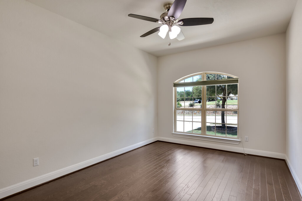 2521 Blended Tree Ranch Drive Leander, TX 78641 - Photo 29 of 40 an empty room with wooden floor chandelier fan and windows