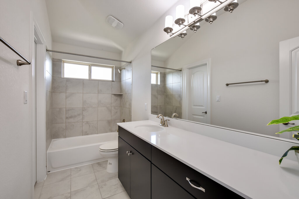 2521 Blended Tree Ranch Drive Leander, TX 78641 - Photo 33 of 40 a bathroom with a tub a sink and mirror
