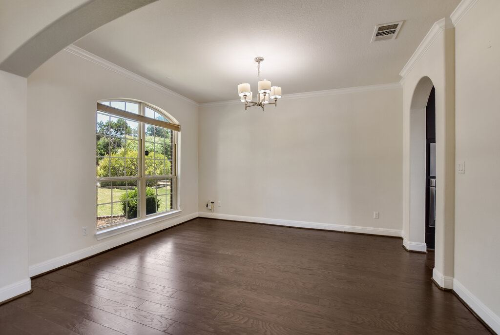 2521 Blended Tree Ranch Drive Leander, TX 78641 - Photo 9 of 40 an empty room with wooden floor chandelier and windows