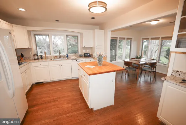 a kitchen with granite countertop a stove and white cabinets