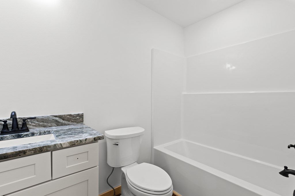 150 Williams Branch Drive Morganton, GA 30560 - Photo 23 of 28 a bathroom with a granite countertop toilet a sink and bathtub