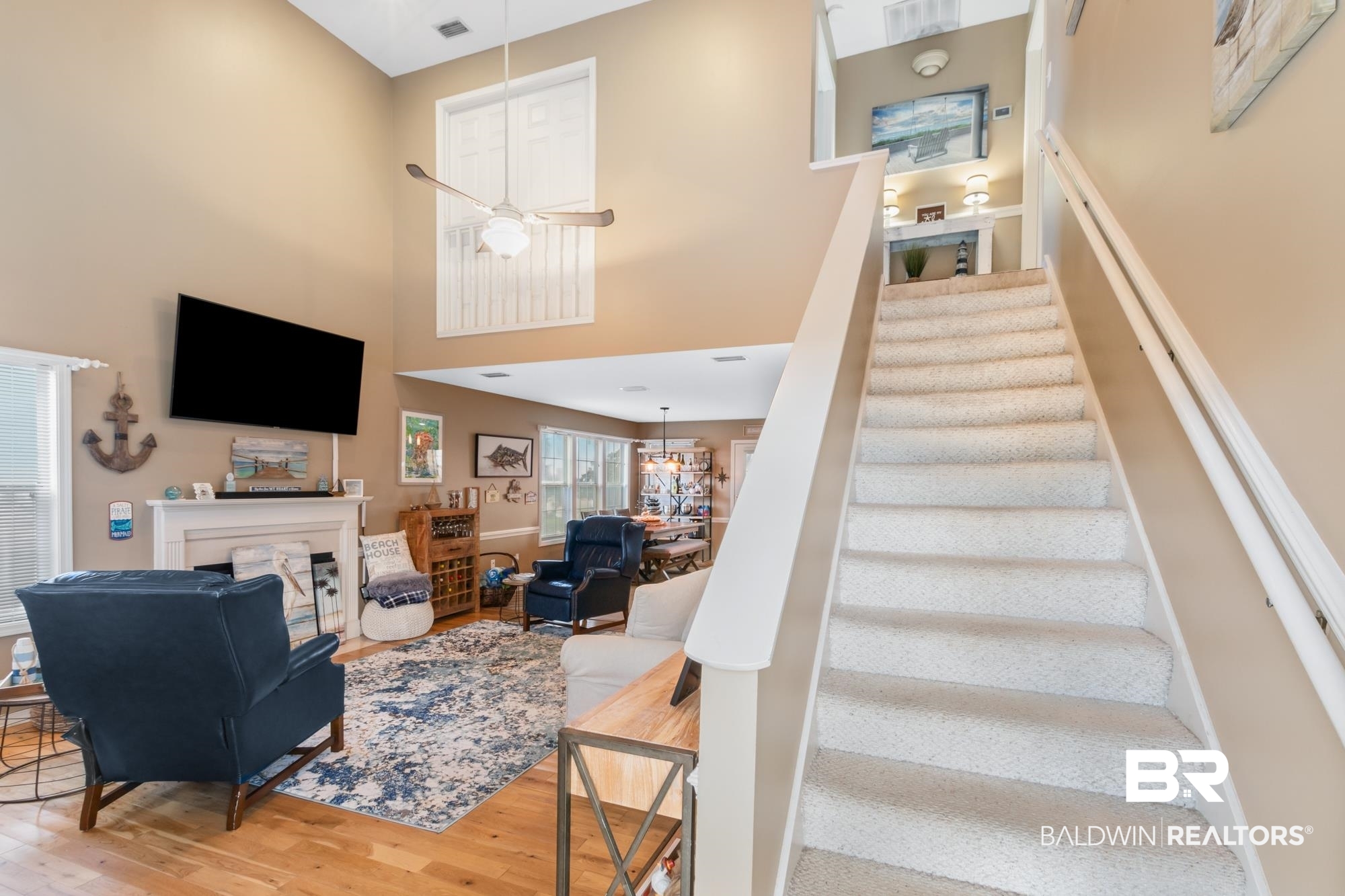 328 Windmill Ridge Road Gulf Shores, AL 36542 - Photo 5 of 47 Stairway featuring wood-type flooring, a towering ceiling, and ceiling fan