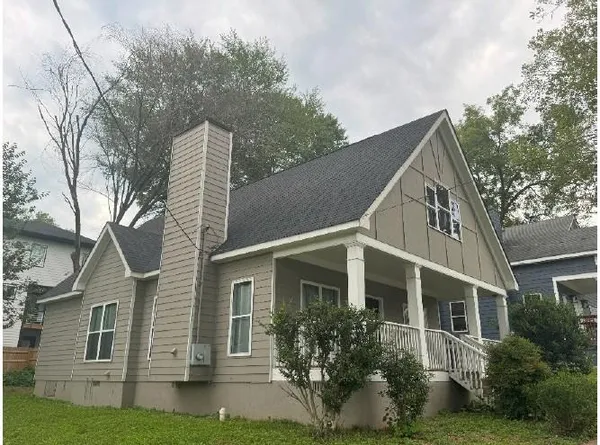 a view of a white house next to a yard