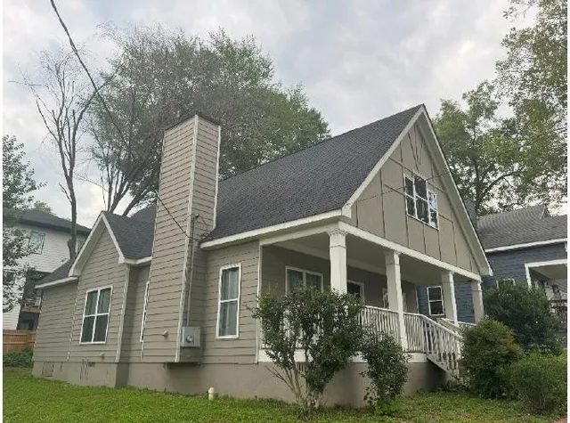 a view of a white house next to a yard