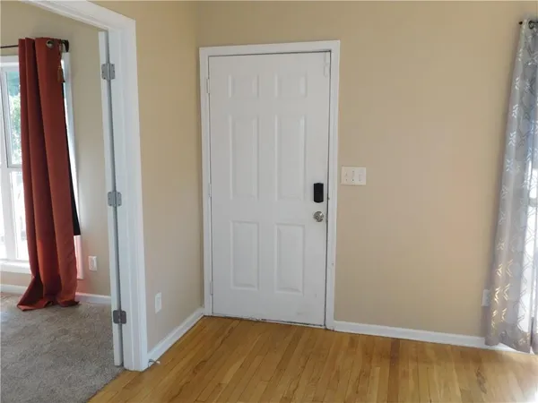 a view of a room with wooden floor and a bathroom