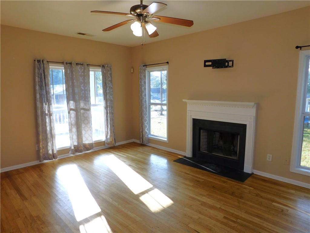 1005 Linam Avenue Southeast Atlanta, GA 30315 - Photo 8 of 29 a view of an empty room with wooden floor fireplace and a window