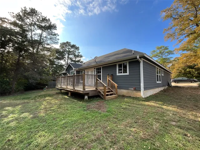 a backyard of a house with wooden fence and large tree