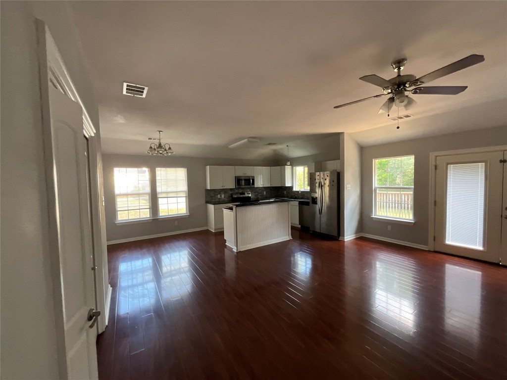239 Old Firetower Road Bastrop, TX 78602 - Photo 39 of 39 a view of a big room with wooden floor and a kitchen