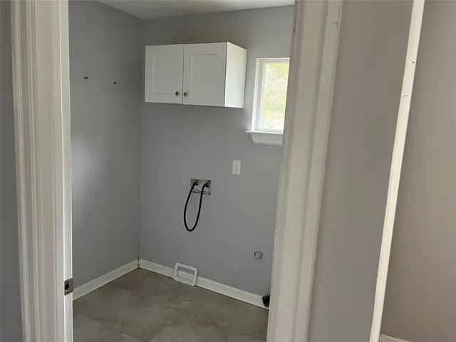 an empty room with wooden floor mirror and windows