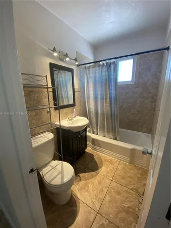 a white toilet sitting next to a bathroom sink and a shower