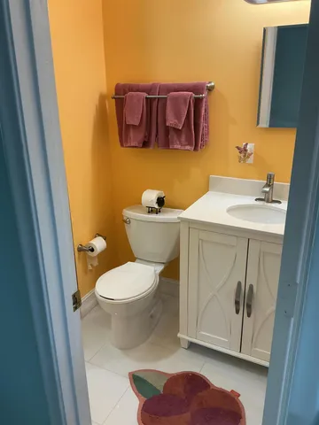 a bathroom with a toilet a sink and mirror