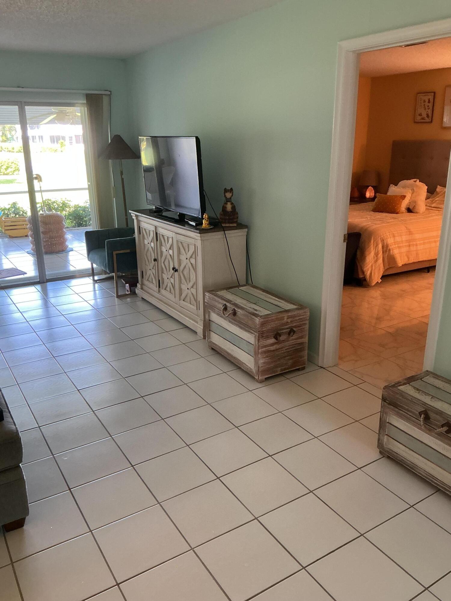 1580 Northwest 18th Avenue, Unit 98B Delray Beach, FL 33445 - Photo 8 of 16 a living room with furniture and a flat screen tv