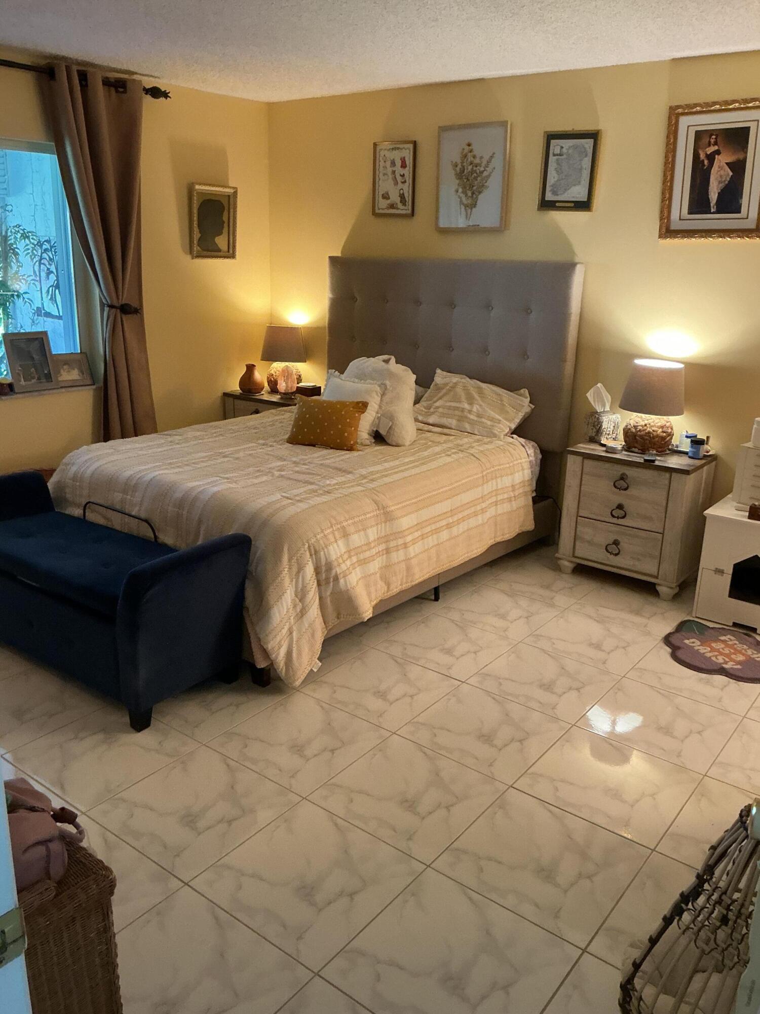 1580 Northwest 18th Avenue, Unit 98B Delray Beach, FL 33445 - Photo 9 of 16 a bedroom with a bed and lamp with window