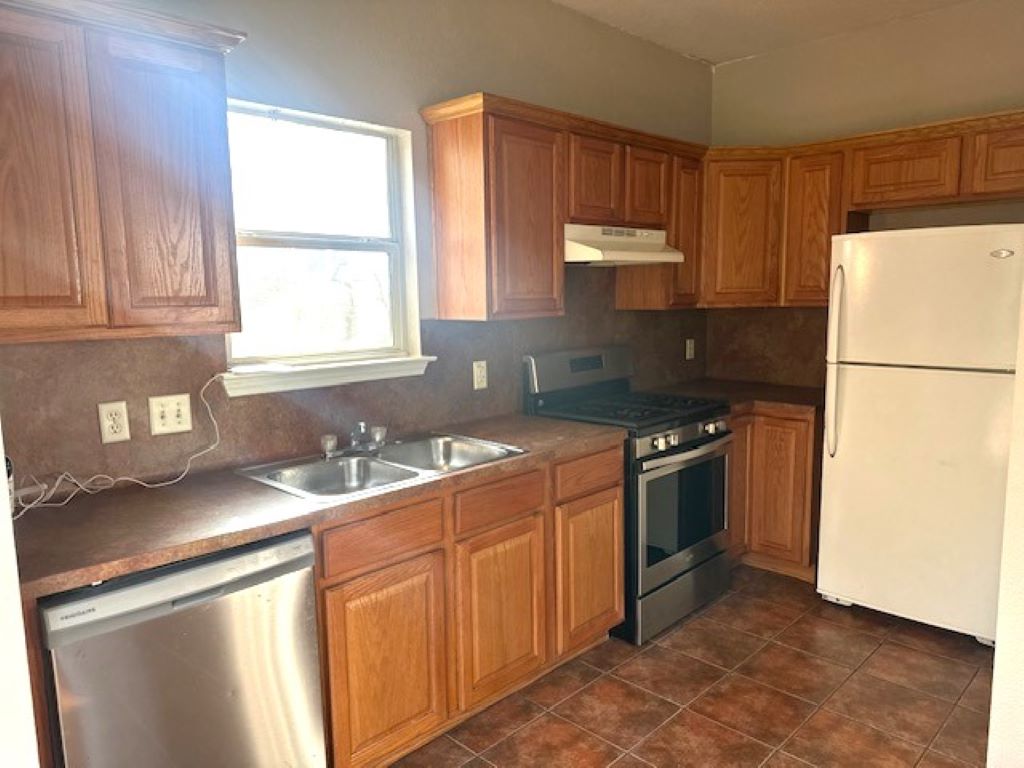 4704 Ledesma Road, Unit A & B Austin, TX 78721 - Photo 17 of 24 a kitchen with stainless steel appliances granite countertop a sink stove and refrigerator