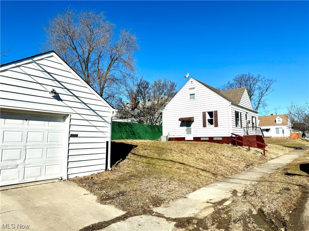 View of side of home with a lawn and a garage
