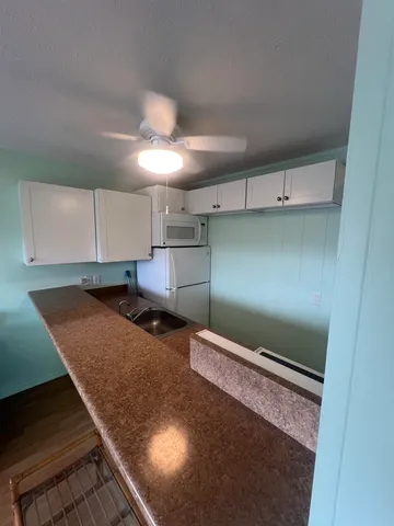 a kitchen with kitchen island a stove and a refrigerator