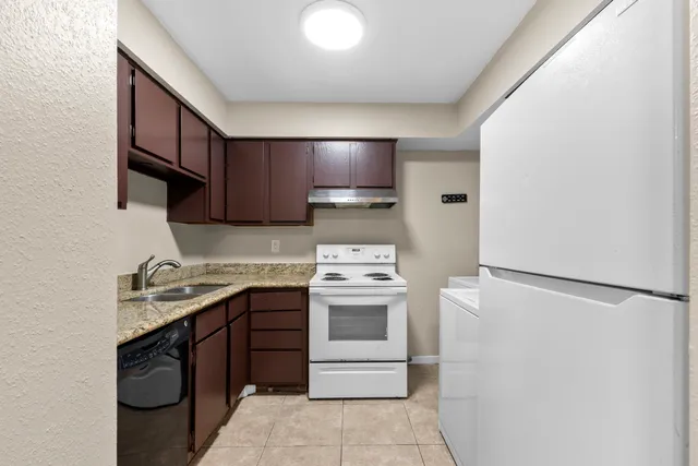 a kitchen with a stove sink and cabinets