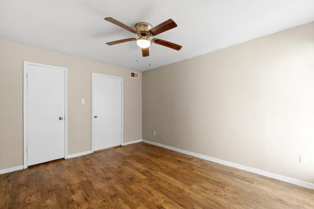 a view of a livingroom with a ceiling fan and wooden floor