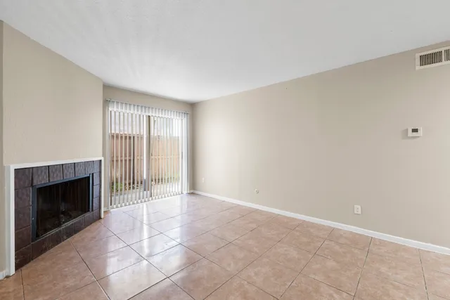 a view of an empty room with a fireplace and a window