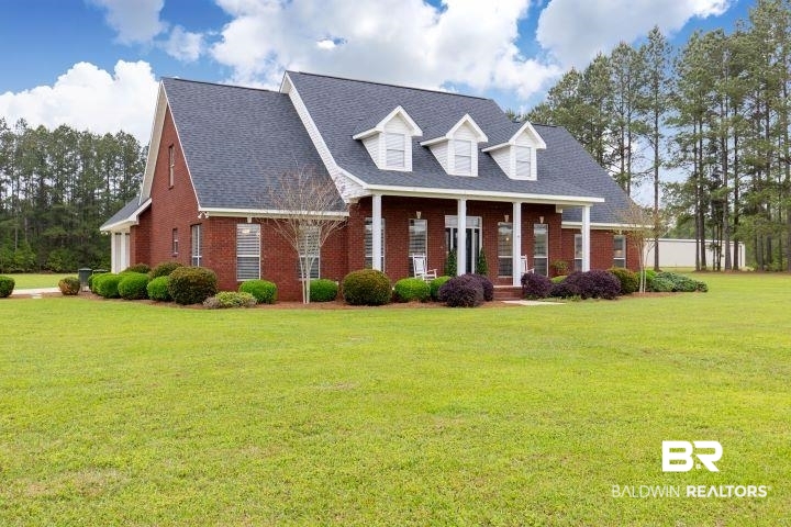 24541 Baldwin Beach Expressway Robertsdale, AL 36567 - Photo 1 of 51 New england style home featuring a front yard and brick siding