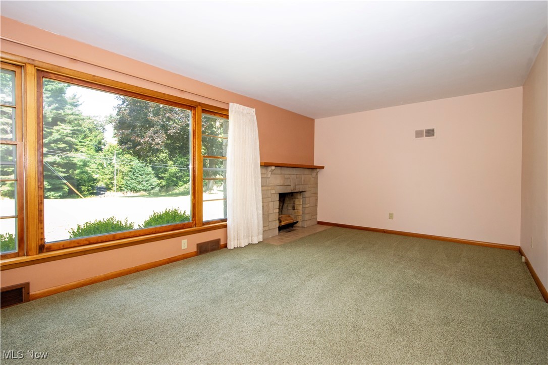 2456 Batdorf Road Wooster, OH 44691 - Photo 10 of 22 Unfurnished living room featuring light carpet and a fireplace with flush hearth