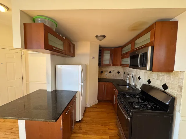 a kitchen with stainless steel appliances granite countertop a stove a sink and a microwave