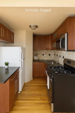 a kitchen with stainless steel appliances granite countertop a stove a sink and a refrigerator