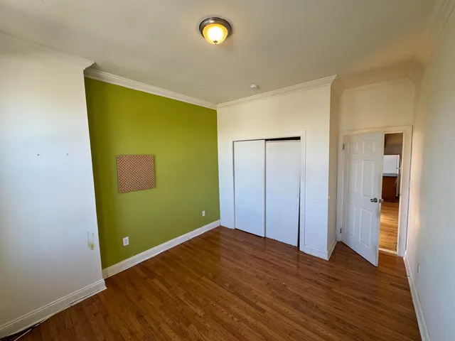 a view of empty room with wooden floor