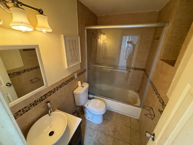 a bathroom with a sink a toilet a mirror and shower